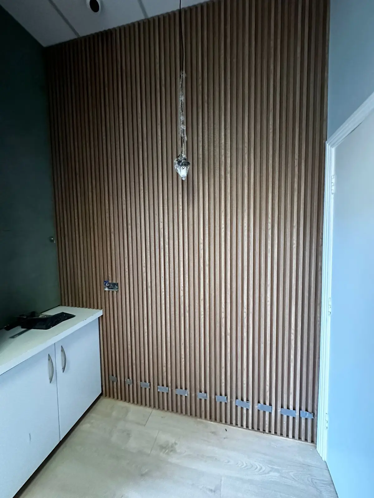 Slatted timber wall panelling with storage unit