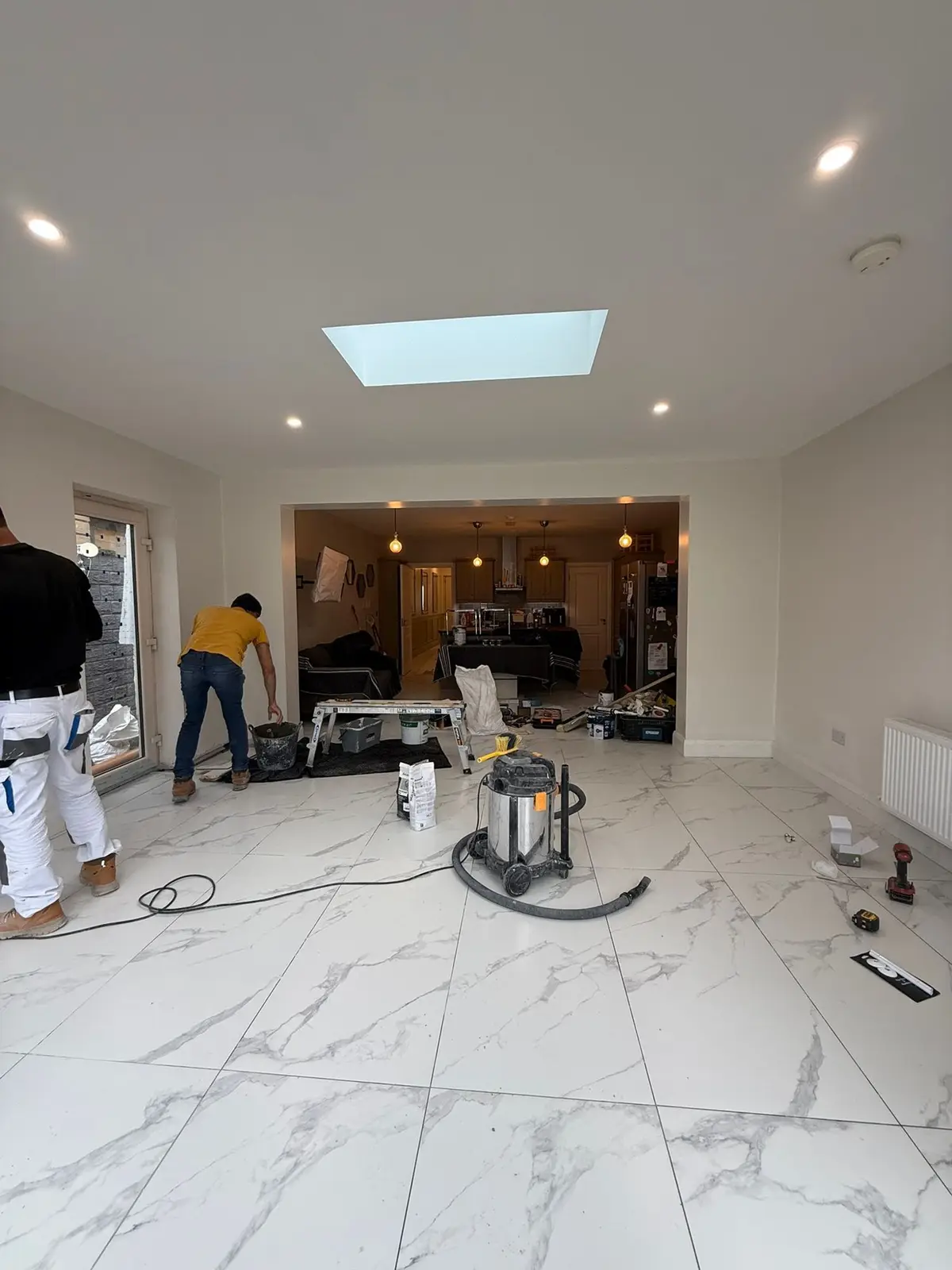 Our crew finishing inside the extension, with the rooflight and opening to the kitchen