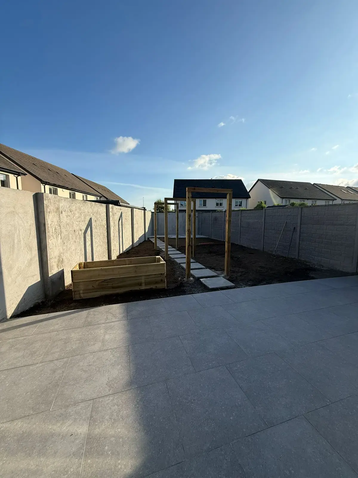 Large format porcelain patio, timber pergola frames and stepping stone path