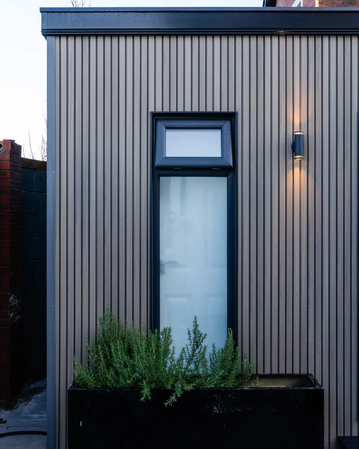 Garden dwelling cladding and window at dusk