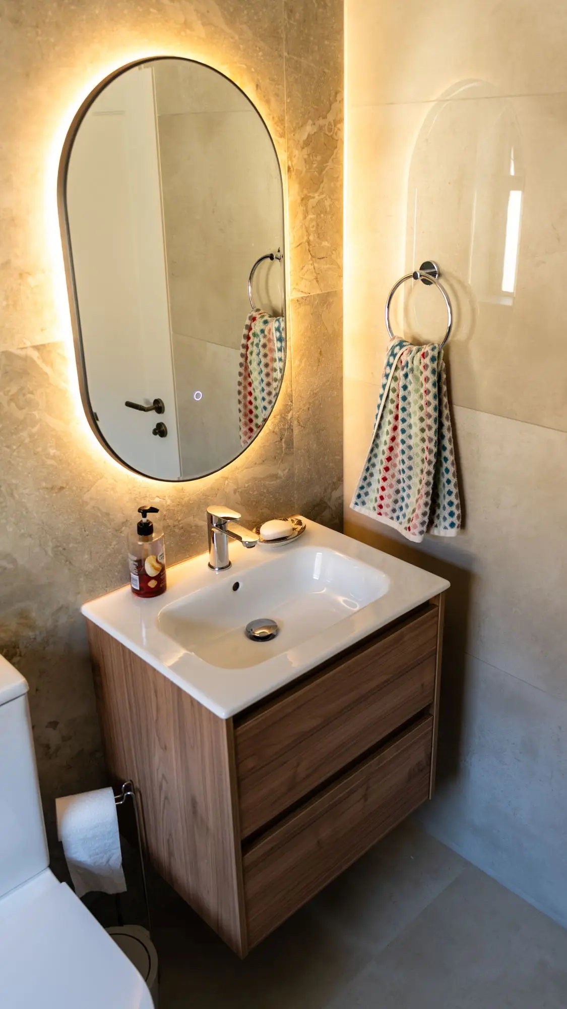 Vanity under a lit oval mirror