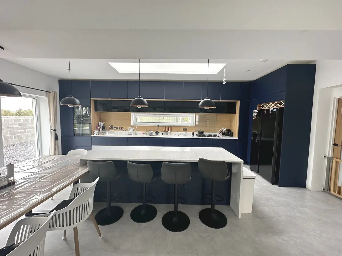 Navy kitchen with island under rooflights