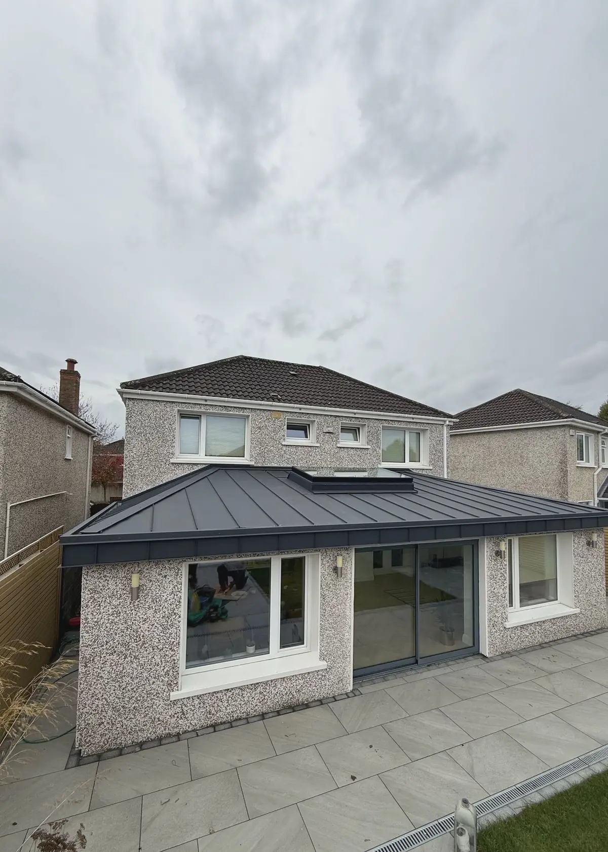 Finished rear extension, standing seam roof, patio