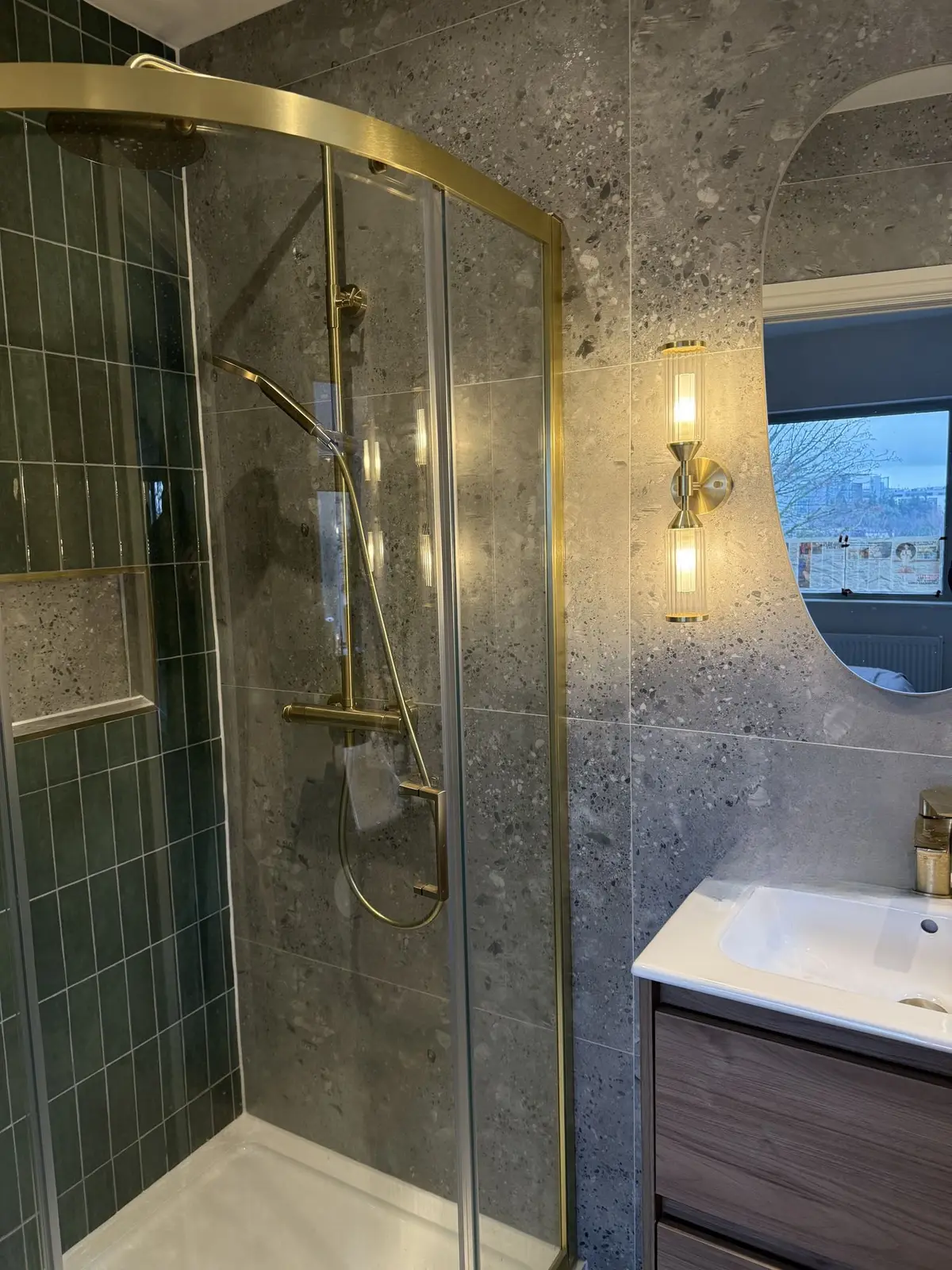 Shower with brass frame, green tile, terrazzo