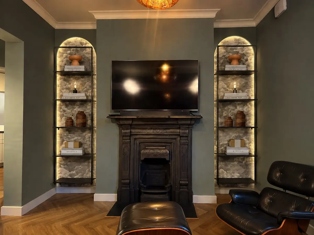 Living room: original fireplace between lit arched shelving