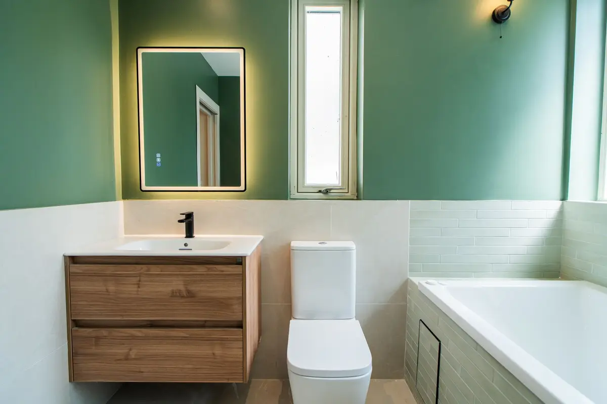 Bathroom with green walls and oak vanity