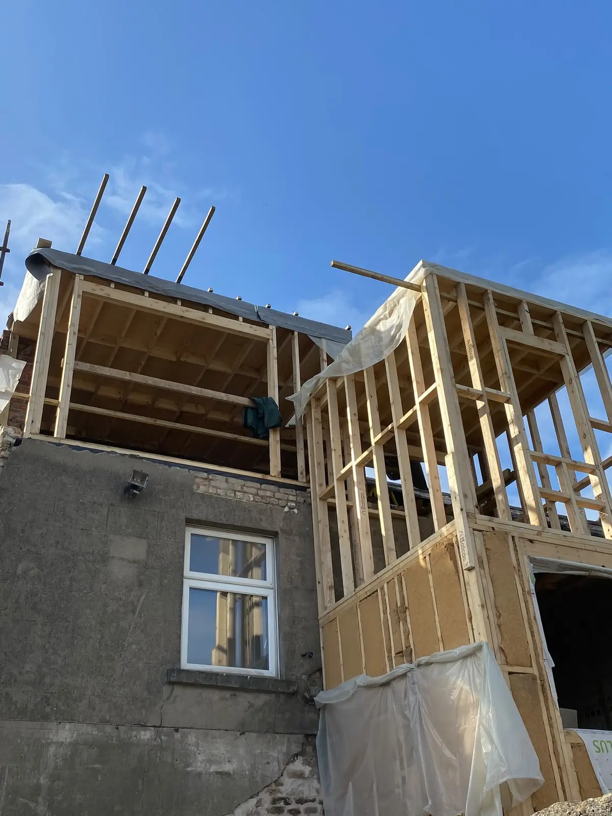 The new timber frame rising above the existing house